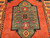 Vintage Kurdish tribal area rug. Hand-woven. Central green medallion on a rich red field. Saffron-colored border with designs in red, green, and blue. Final outer border in green. Small size.