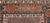 Late 19th Century Antique Kurdish rug. Hand-woven. Paisley pattern variation. Dark brick red background. Rust-colored border with a large design. Narrow cream inner and outer borders.