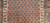Late 19th Century Antique Kurdish rug. Hand-woven. Paisley pattern variation. Dark brick red background. Rust-colored border with a large design. Narrow cream inner and outer borders.