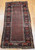 Late 19th Century Antique Kurdish rug. Hand-woven. Paisley pattern variation. Dark brick red background. Rust-colored border with a large design. Narrow cream inner and outer borders.
