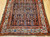 Early 20th Century Vintage Persian Malayer area rug. Hand-knotted. All-over paisley "seed of life" pattern. Navy blue field. Paisley forms in green, blue, yellow, pink. White border with flower designs in red, yellow, green, pink. Artisan village weaving.