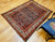 Early 20th Century Vintage Persian Malayer area rug. Hand-knotted. All-over paisley "seed of life" pattern. Navy blue field. Paisley forms in green, blue, yellow, pink. White border with flower designs in red, yellow, green, pink. Artisan village weaving.