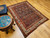 Early 20th Century Vintage Persian Malayer area rug. Hand-knotted. All-over paisley "seed of life" pattern. Navy blue field. Paisley forms in green, blue, yellow, pink. White border with flower designs in red, yellow, green, pink. Artisan village weaving.