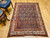 Early 20th Century Vintage Persian Malayer area rug. Hand-knotted. All-over paisley "seed of life" pattern. Navy blue field. Paisley forms in green, blue, yellow, pink. White border with flower designs in red, yellow, green, pink. Artisan village weaving.