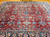 Vintage Persian Mahal Sultanabad room size rug. Hand-woven. Allover design of large geometric and floral forms. Red field. Dark navy blue border. Colors: bright reds, French blue, navy, pink, and other shades.