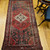Vintage Persian Hamadan rug in medallion pattern with moss green, red, ivory, and turquoise border featuring geometric and animal motifs.