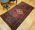 Vintage Persian Hamadan rug in medallion pattern with moss green, red, ivory, and turquoise border featuring geometric and animal motifs.