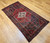 Vintage Persian Hamadan rug in medallion pattern with moss green, red, ivory, and turquoise border featuring geometric and animal motifs.