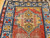Handwoven early 20th century Kazak rug featuring bold royal blue and yellow medallions on rich red background, The Persian Knot Gallery, SKU 1787