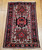 Vintage Persian Heriz Karajeh rug with three medallions in green and red on a cream field, framed by a navy border, hand-knotted circa 1900s.