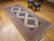 Mid-20th Century Vintage Persian Malayer gallery or corridor size rug. Handwoven. Open-field design on camel hair background. Three axial medallions in deep navy with geometric motifs in baby blue, pink, French blue. Cream field with paisley motif. Corner