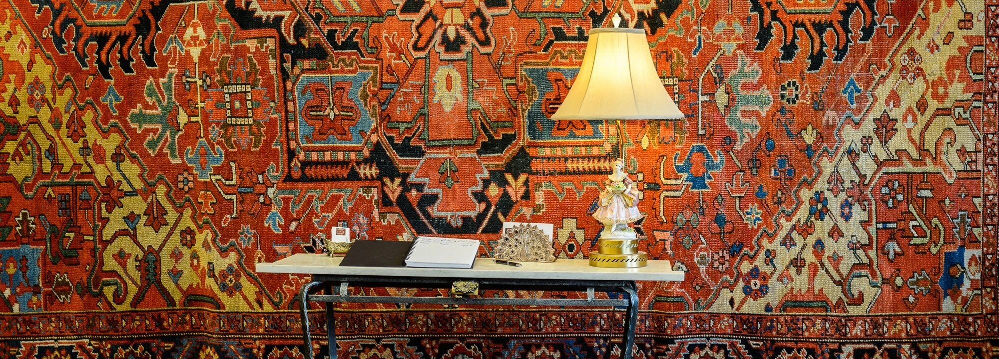 An antique Heriz rug displayed on the wall at The Persian Knot Gallery