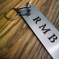 Stainless steel golf bag tag with integrated bottle opener