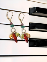 Triple drop Swarovski crystal earrings on 14 karat gold filled metal displayed on piano