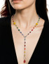 curtis wearing rainbow pride hoop earrings with rainbow necklace designed for pride month. wearing as a y necklace in image.