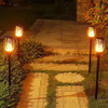 Captivating photo showcasing the Solar Powered LED Flame Effect Yard/Landscape Torch Light in action. The eco-friendly torch light, powered by solar energy, emits a mesmerizing flickering flame effect, adding a warm and enchanting glow to any outdoor space. The beautifully designed torch light stands tall amidst a lush garden, illuminating pathways and creating a captivating ambiance. Enjoy the hassle-free installation and energy-efficient performance of this stunning torch light for a magical outdoor experience.