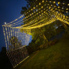 A stunning 10' x 30' warm white LED light curtain is gracefully displayed, with 3,600 tiny glowing lights cascading down in evenly spaced rows. The warm white light creates a soft, inviting ambiance, ideal for festive events or cozy décor. The expansive size provides a dramatic effect, covering a large walls, windows, or outdoor spaces. The gentle glow of the LEDs beautifully illuminates the surroundings, offering a magical, twinkling backdrop perfect for any occasion.