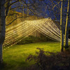 A stunning 10' x 30' warm white LED light curtain is gracefully displayed, with 3,600 tiny glowing lights cascading down in evenly spaced rows. The warm white light creates a soft, inviting ambiance, ideal for festive events or cozy décor. The expansive size provides a dramatic effect, covering a large walls, windows, or outdoor spaces. The gentle glow of the LEDs beautifully illuminates the surroundings, offering a magical, twinkling backdrop perfect for any occasion.
