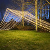 A stunning 10' x 30' warm white LED light curtain is gracefully displayed, with 3,600 tiny glowing lights cascading down in evenly spaced rows. The warm white light creates a soft, inviting ambiance, ideal for festive events or cozy décor. The expansive size provides a dramatic effect, covering a large walls, windows, or outdoor spaces. The gentle glow of the LEDs beautifully illuminates the surroundings, offering a magical, twinkling backdrop perfect for any occasion.