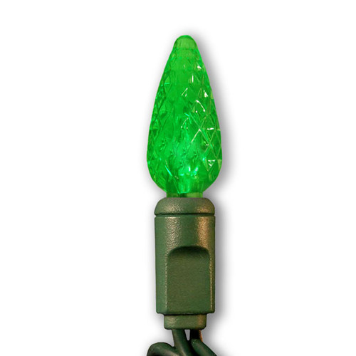 Green C6 faceted LED Christmas light bulb mounted on a green plastic socket with a dark green wire. The bulb has a textured, diamond-cut surface that enhances its glowing effect when illuminated. Green C6 faceted LED Christmas light bulb mounted on a green plastic socket with a dark green wire. The bulb has a textured, diamond-cut surface that enhances its glowing effect when illuminated.