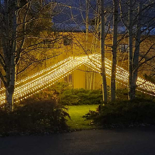 A stunning 10' x 30' warm white LED light curtain is gracefully displayed, with 3,600 tiny glowing lights cascading down in evenly spaced rows. The warm white light creates a soft, inviting ambiance, ideal for festive events or cozy décor. The expansive size provides a dramatic effect, covering a large walls, windows, or outdoor spaces. The gentle glow of the LEDs beautifully illuminates the surroundings, offering a magical, twinkling backdrop perfect for any occasion.