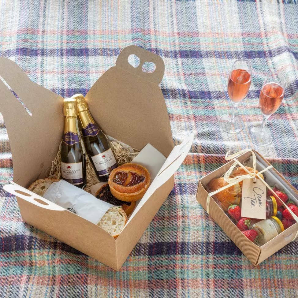 Two boxes on a rug, one open with content on show, the other is closed but with a transparent lid