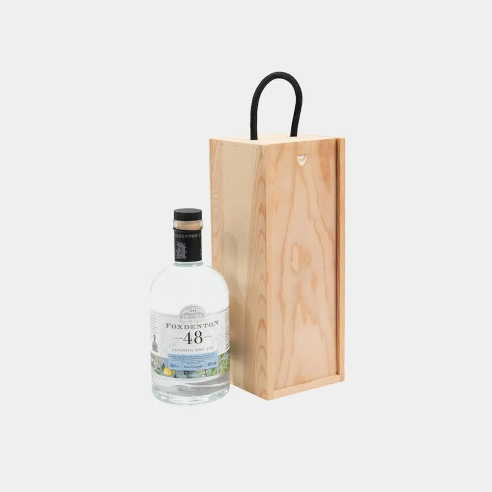 A gin bottle next to a wooden container for bottles