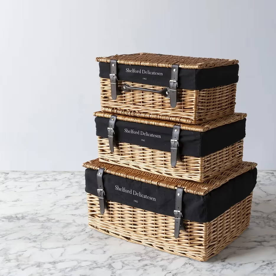 Three wicker hampers sitting on top of each other, largest at the bottom to the smallest on the top