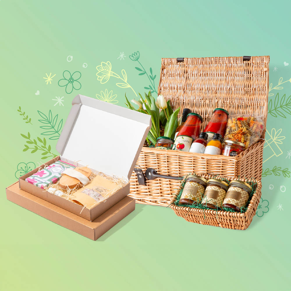 A hamper with bottled items and shred, with boxes in front and a wicker tray