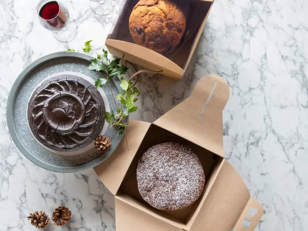 Two boxes, top down with open lids, with simple cakes inside