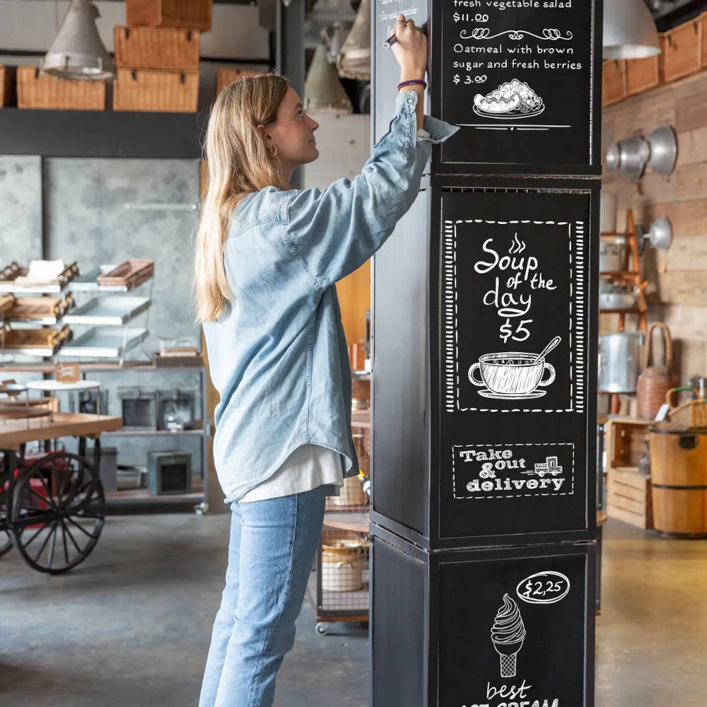 A woman standing by a chalkboard writing