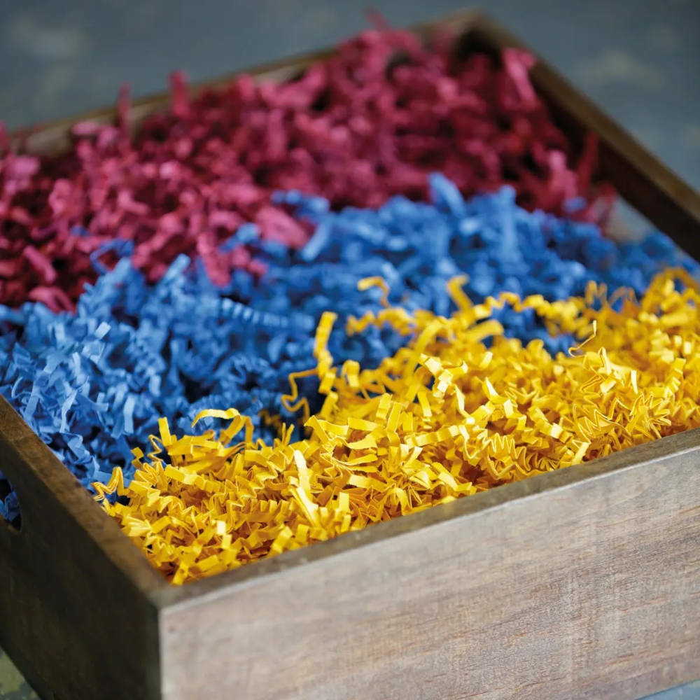 A box of shredded paper in red, blue and yellow