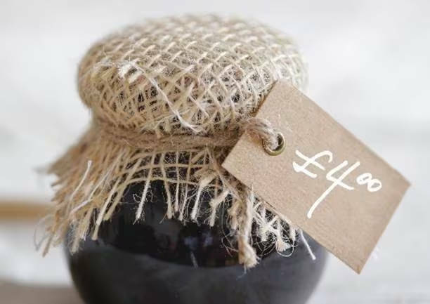 Close up picture of a jar with a jute cover and a string label