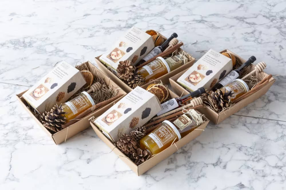 Four hamper trays on a marble table with the same set of items in each