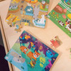 Playscapes 3-Branch Discovery Mini Activity Table, colorful animal-themed puzzle pieces depicting a zoo, jungle, and farm scenes on wooden table.