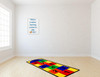 Learning Carpets Hopscotch Play Carpet, colorful hopscotch game rug with numbered squares on wooden floor in a bright room.