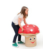 Novum Toadstool Soft Stool & Table for Kids, a girl playing with a mushroom-shaped soft stool and table set that features a cheerful face and a bright red mushroom cap with white spots.