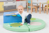 Moje Bambino Multi-Sensory Pouf Set, a colorful foam play area with a baby crawling on it in a playroom. Moje Bambino Multi-Sensory Pouf Set, a colorful foam play area with a baby crawling on it in a playroom.