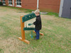 Infinity Playgrounds Chime Wall Activity Center, a child playing with a musical instrument on an outdoor activity wall.