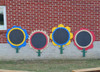 Infinity Playgrounds Chalkboard Flowers - Daisy, Rose or Sunflower, colorful flower-shaped chalkboards mounted outdoors against a brick wall.