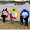 Infinity Playgrounds Fruit Outdoor Art White Board Activity Panels, children drawing on colorful fruit-shaped white boards in a playground setting.