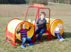 Infinity Playgrounds Steam Roller Double Tunnel Playground Climber, kids playing inside yellow tunnel slides on a playground in an open grassy field.