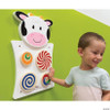 SPARK & WOW Cow Activity Wall Panel, children interactive toy with colorful spinning and swirling discs on a green wall.