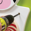 SPARK & WOW Cow Activity Wall Panel Toy, close-up of a person using a screwdriver to assemble or adjust the toy on a colorful green and white wall panel. SPARK & WOW Cow Activity Wall Panel Toy, close-up of a person using a screwdriver to assemble or adjust the toy on a colorful green and white wall panel.