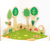 Moje Bambino Forest w/Hedgehog Sensory Wall Panel, wooden nursery wall panel with tree designs, sensory toys, and colorful mushroom decorations on a vibrant green floral rug.