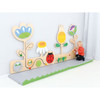 Moje Bambino Meadow Sensory Wall Panel, colorful wooden nature-themed sensory play panel for children with flowers, ladybug, and leaf accents in a playroom.