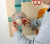 HABA Pro Mechanic Sensory Wall Panel, child playing with the interactive wooden mechanic-themed sensory wall panel.