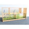 Whitney Brothers Nature View Acrylic Back Storage Cabinet 24 H, wooden storage cabinet with a nature-themed printed acrylic back panel featuring grass, flowers, and plants.