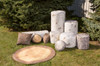 Playscapes Woodsmen Naturescape Tree Stump, assorted nature-inspired wooden tree stumps and a large wooden slab for outdoor decorative or play purposes.