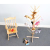 Whitney Brothers Puppet Storage Tree, wooden puppet storage tree with multiple pegs holding various plush animal puppets next to a wooden chair with puppets on it.